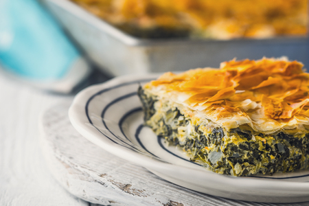 Greek pie spanakopita in the ceramic plate on the white  table  horizontalの写真素材