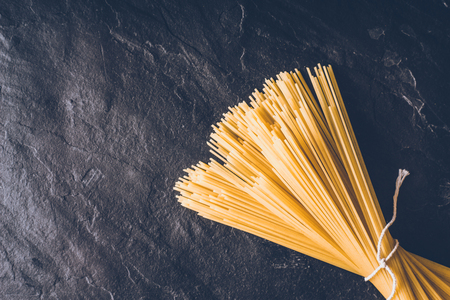 Raw spaghetti on the black stone background top viewの写真素材