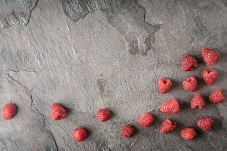 Raspberries on the dark stone background  top view