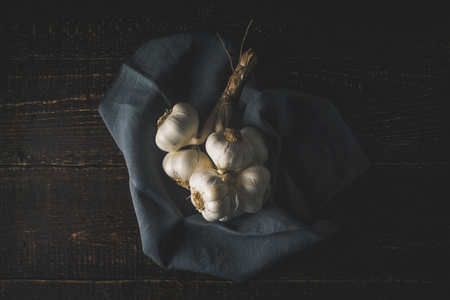 Bunch of garlic with napkin on the wooden table top viewの写真素材