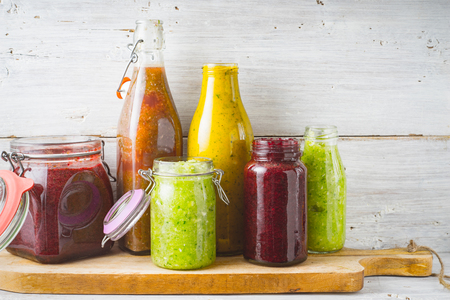 Bottles and jar with different smoothie on the  wooden board horizontalの写真素材