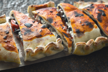 Sliced calzone on the stone background horizontalの写真素材