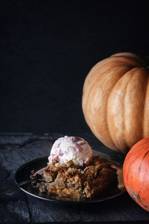Pumpkin dump cake with ice cream on the stone table verticalの写真素材