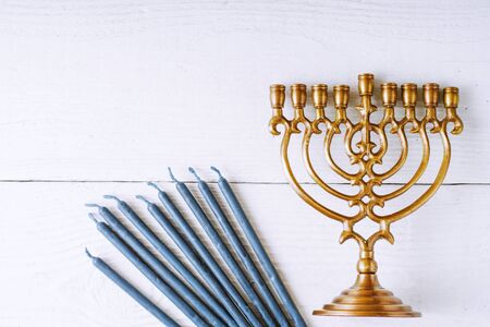 Hanukkah menorah and candles on the white wooden table top view