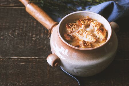 Ceramic pot with onion soup on the wooden table  horizontalの写真素材
