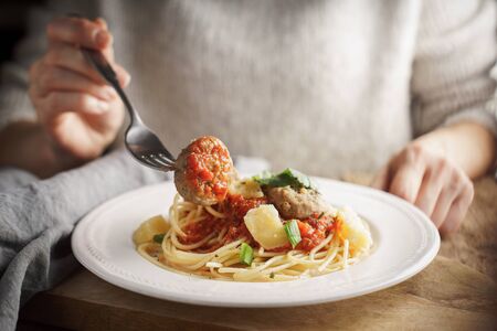 Woman eating meatballs horizontalの写真素材