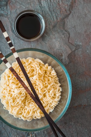 Soup Ramen noodles in glass bowl on tte gray table verticalの写真素材