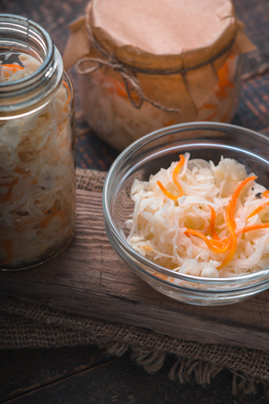 Banks and saucer with sauerkraut on a wooden boards verticalの写真素材