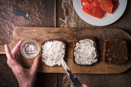 Smearing butter on bread slices of salmon horizontalの写真素材