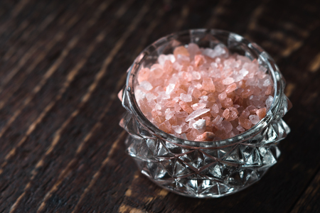 Pink salt in a bowl on a wooden table horizontalの写真素材
