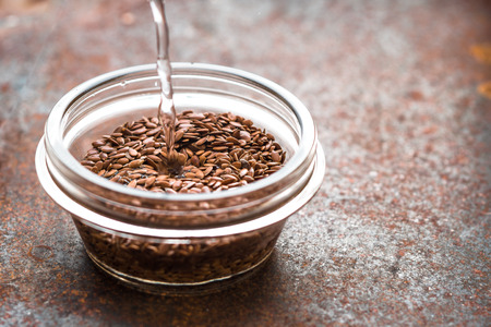 Adding water in the bowl with flax seedの写真素材