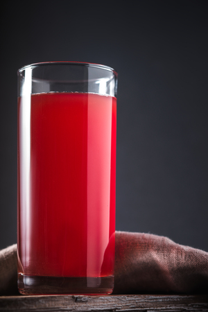 Cranberry drink in a tall glass on a gray background verticalの写真素材