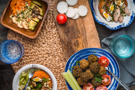 Falafel, salads with pumpkin, carrots, avocado on a wicker napkin horizontal