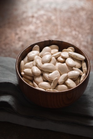 Large white beans in a wooden bowl side viewの写真素材