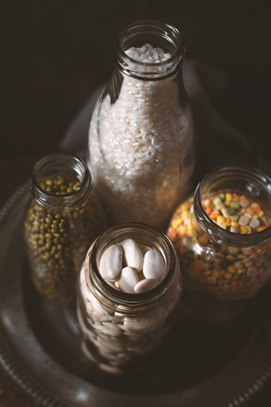 Lentils, white beans, rice in glass bottles side viewの写真素材