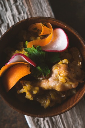 Salad of beans, chicken, carrots, radishes in a wooden bowlの写真素材