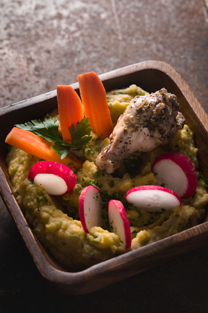 Puree beans, chicken, carrots, radishes in a bowlの写真素材