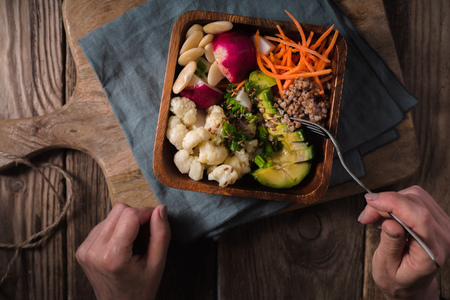 Woman eating vegetable salad from a bowlの写真素材