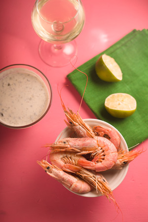 Glass with white wine, lime on a green napkin, shrimp in a bowlの写真素材