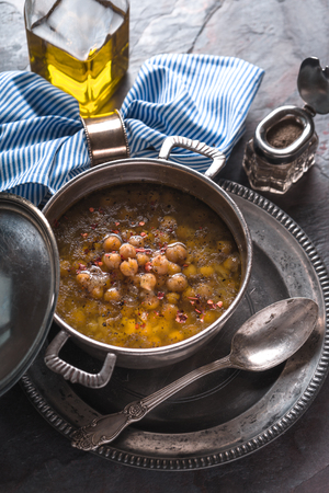 Greek chickpea soup in the pot on the metal background top view verticalの写真素材