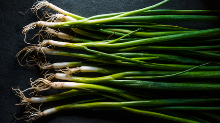 Harvest of green onions on the table surface horizontal