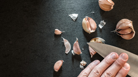 Peeling the garlic with a knife horizontalの写真素材