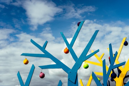 Abstract tree shapes against a blue sky with cloudsの写真素材