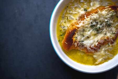 Onion soup with a toast in a white ceramic bowlの写真素材