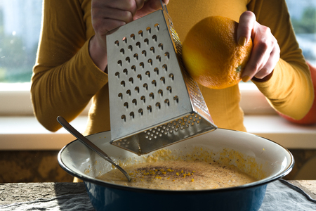 Bowl with a filling for a pumpkin pie, an orange and zest and a graterの写真素材