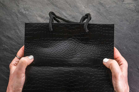 Black Friday sale, black package in female hands