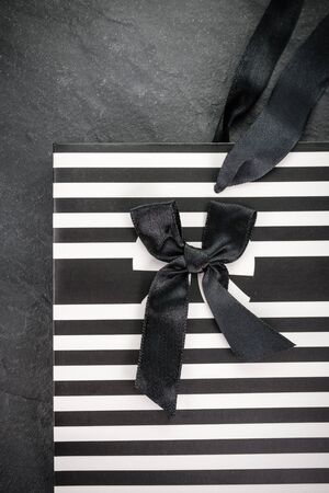 Paper bag in strip with black bow close-upの写真素材