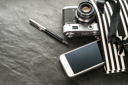 Phone, camera, pen in a black package with white stripes with the rightの写真素材
