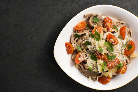 Italian pasta with cheese and cherry in a ceramic plateの写真素材