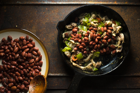 Beans are spread in a frying pan with pepper and chicken.の写真素材