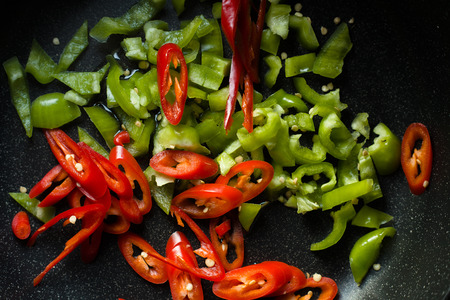 Green and red peppers for fajita in a frying pan top viewの写真素材