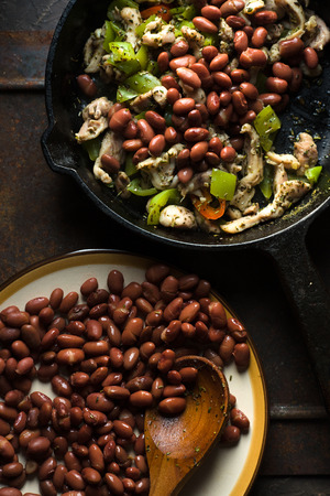 Beans are spread in a frying pan with pepper and chicken top viewの写真素材