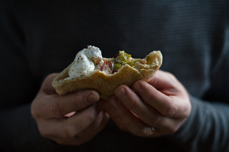 Man holds a bite of fajita in his hands horizontalの写真素材