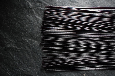 Black dry rice noodles on black stone free spaceの写真素材