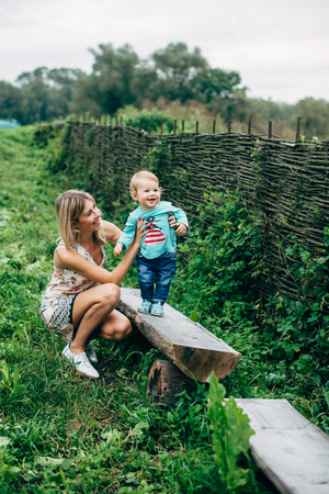Mom and son walk in the park outside the city in the eveningの写真素材