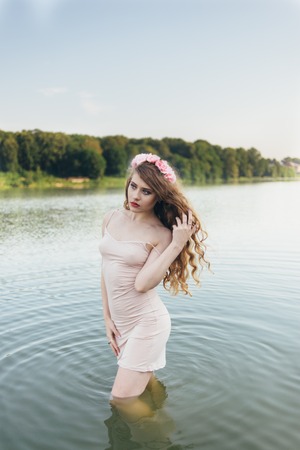 girl in a dress in the water at dawnの写真素材