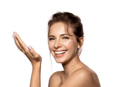 Portrait of beautiful woman using cream for facial skin.