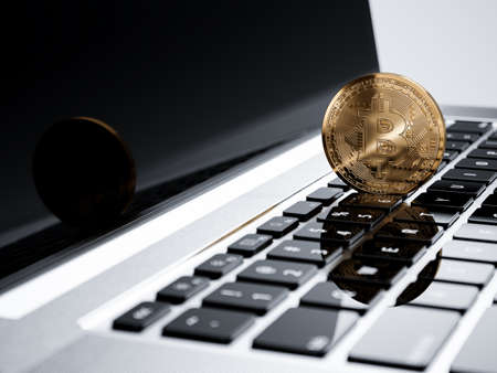 Bitcoin golden coin on computer laptop keyboard button. Cryptocurrency mining and trading technology...