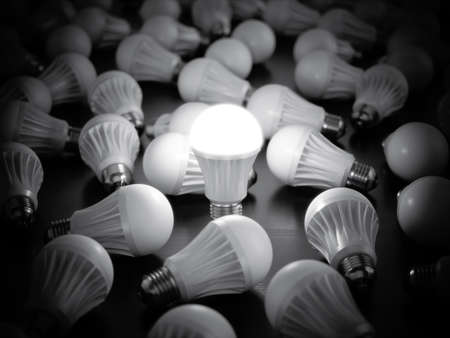 LED light bulbs with glowing one on dark table background. 3d rendering illustration