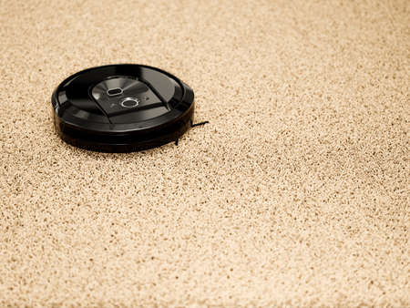 Robotic vacuum cleaner on a carpet floor. 3d rendering illustration. Smart cleaning modern technologyの写真素材