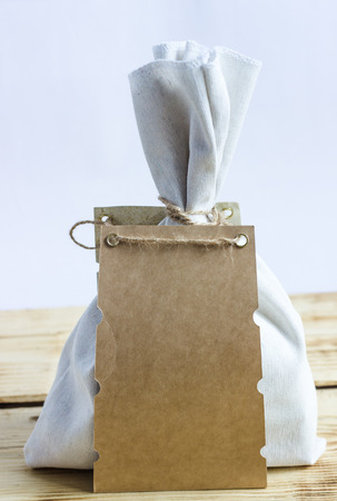 Fabric bag with a place for writing on a wooden tableの写真素材
