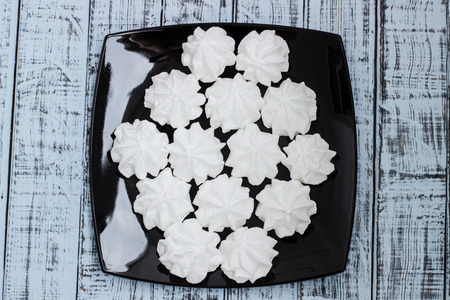 White meringue cookies on a plate. Sweet snack.の写真素材