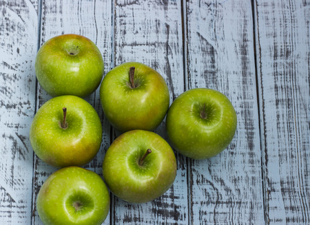 Fresh green apples on vintage wooden background. Detox, diet or healthy food concept