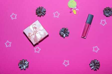 New Year decorations on a bright pink background. Gift box, Christmas cones and stars on a Christmas background.の写真素材