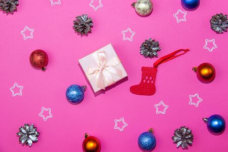 New Year decorations on a bright pink background. Gift box, Christmas cones and stars on a Christmas background.の写真素材
