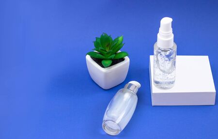Cosmetic bottles with serum, gel, face cream on a blue background. Skin cosmetics, minimalism. The...